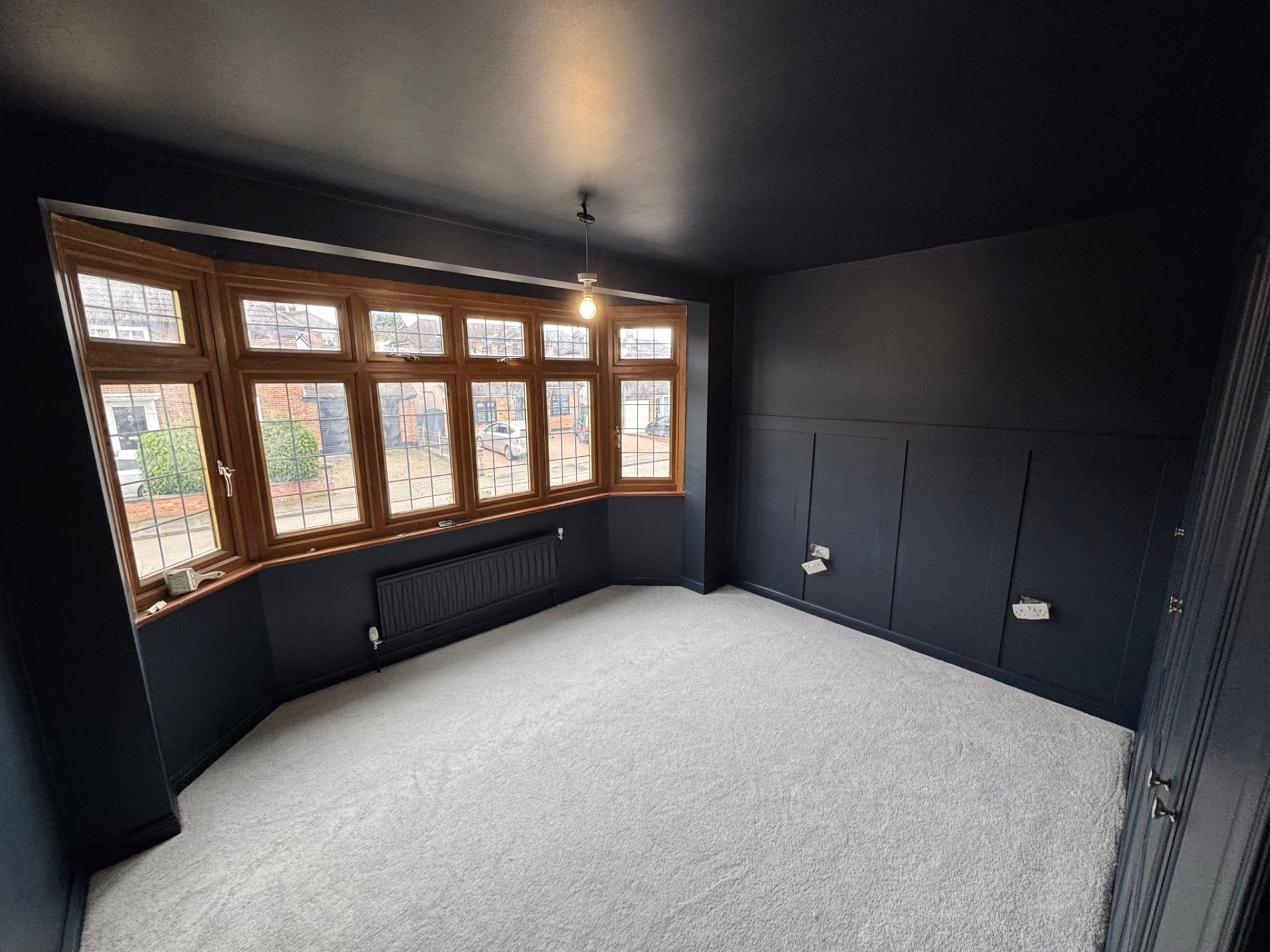 Bedroom decorated in charcoal with panelling and original bay window